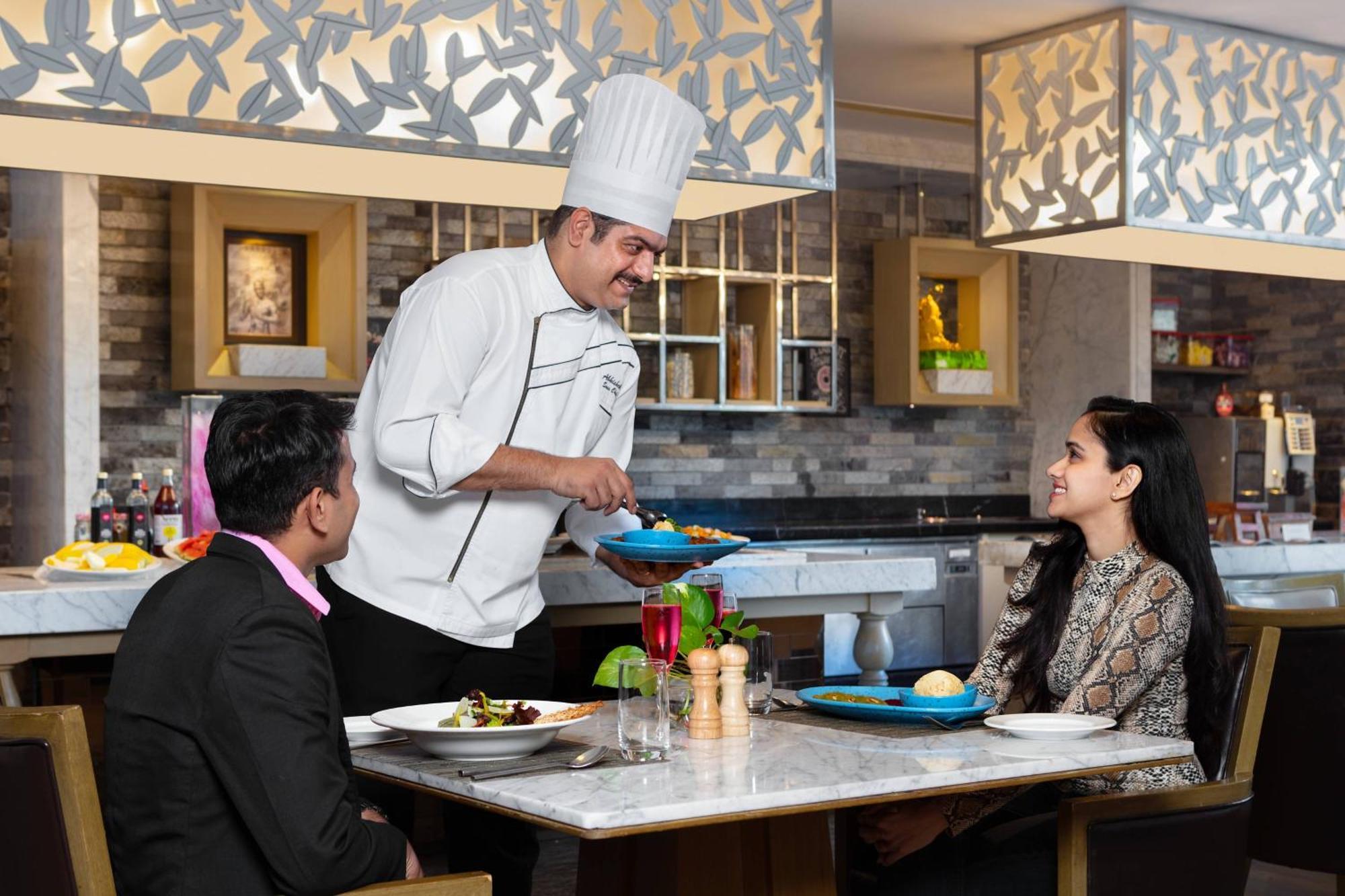 Отель Courtyard By Marriott Agra Экстерьер фото A chef serving food to guests